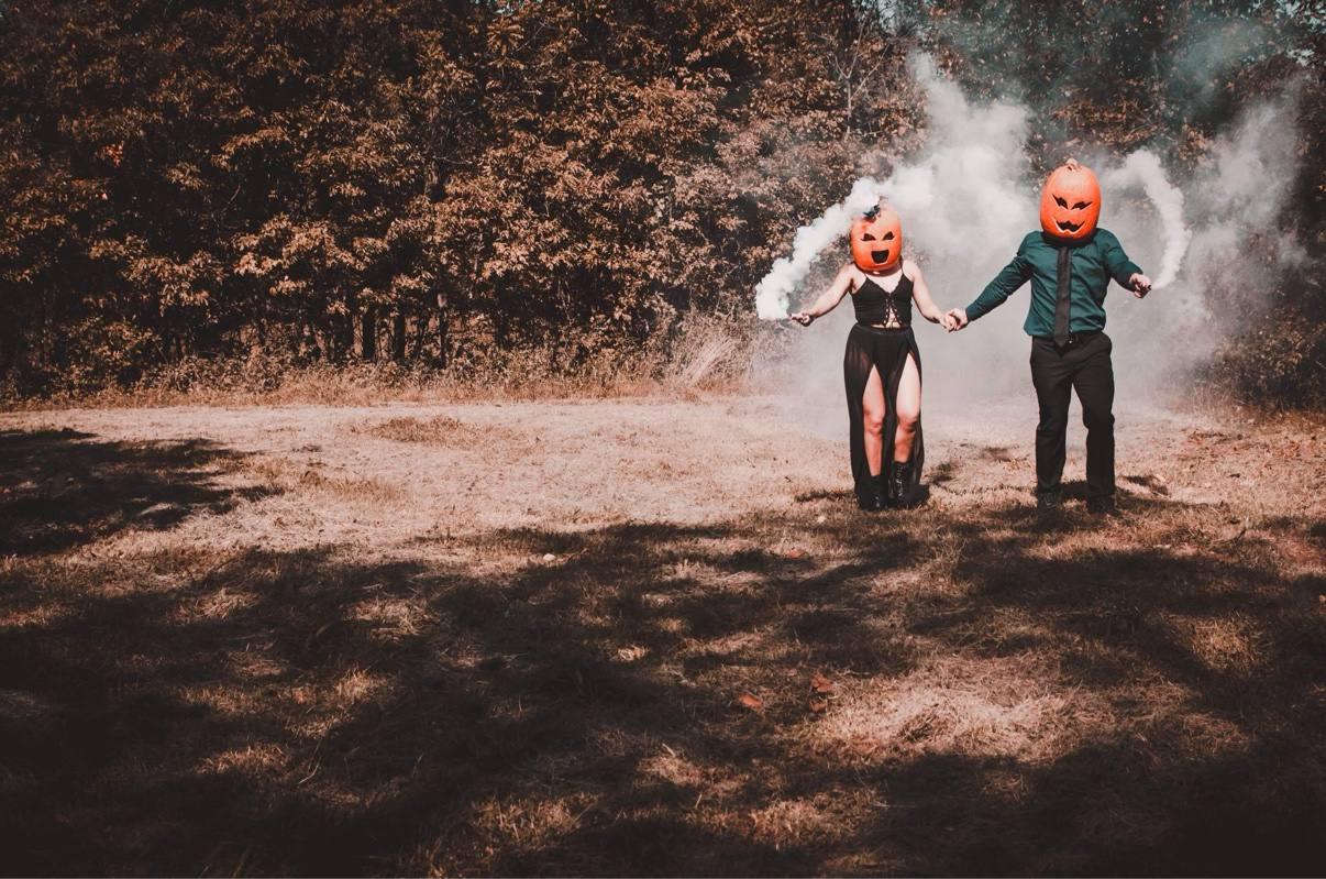 Two children running hand in hand down a woodland path