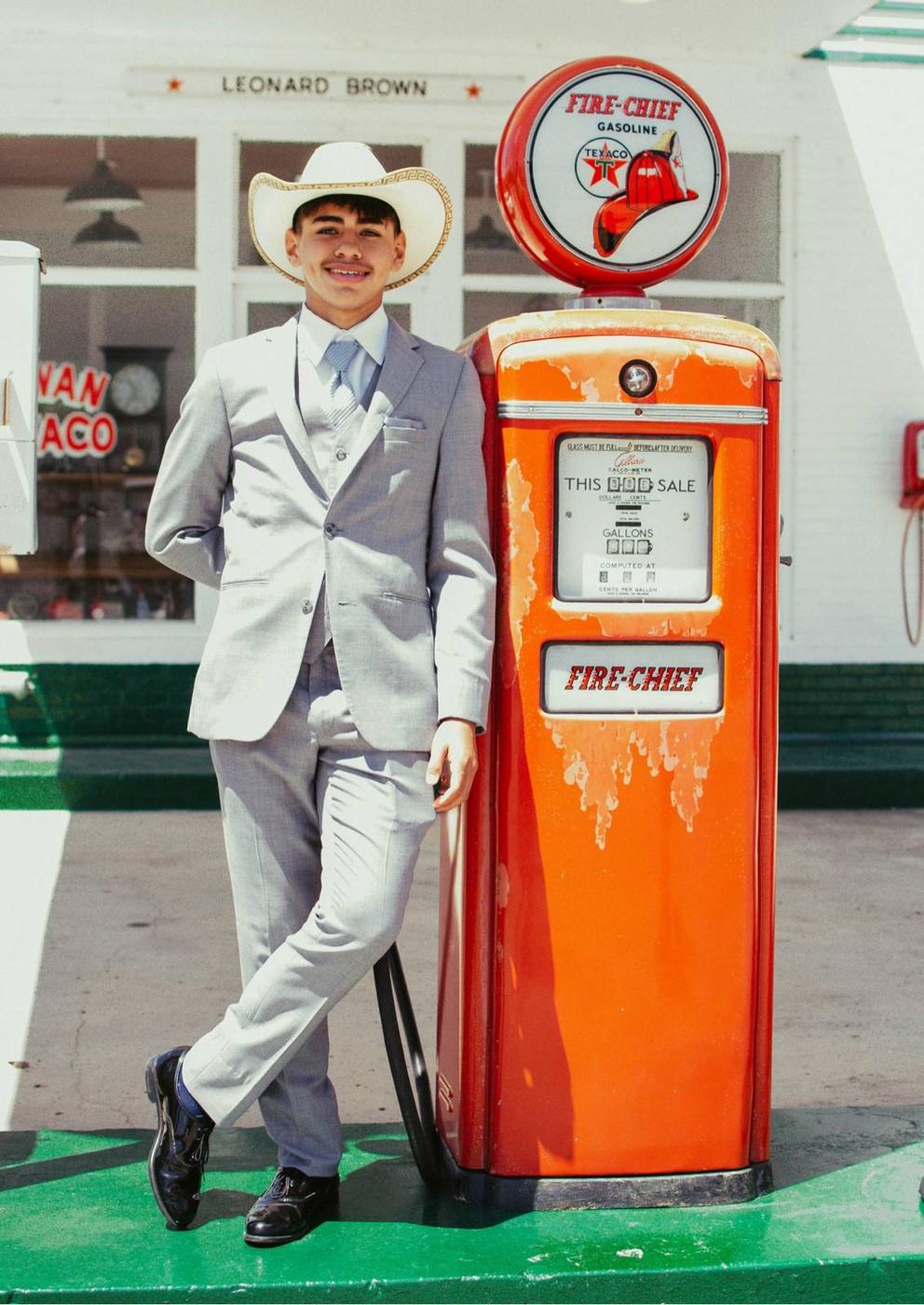 A senior portrait beside an orange vintage gas pump