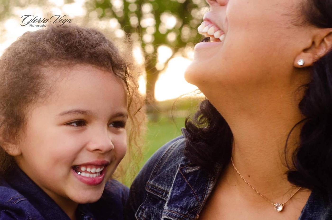 A mother and daughter laughing together in warm evening light