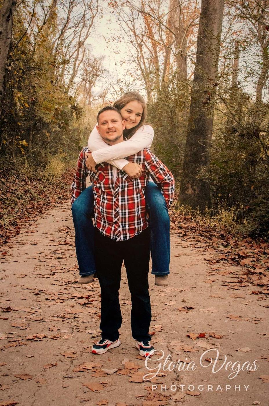 A woman kissing a man’s cheek while riding piggyback outdoors