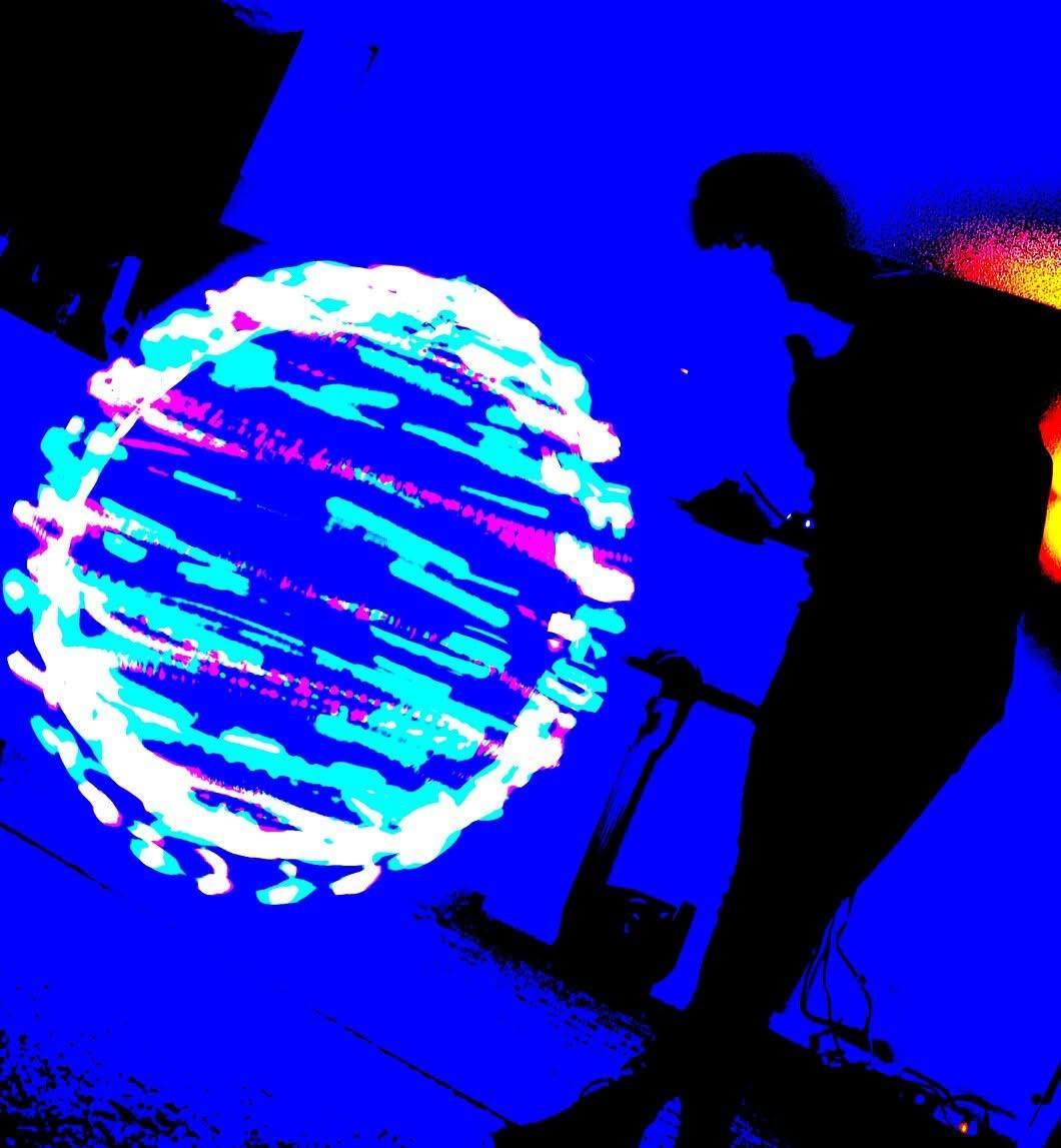 A silhouetted figure beside a vivid circular light painting