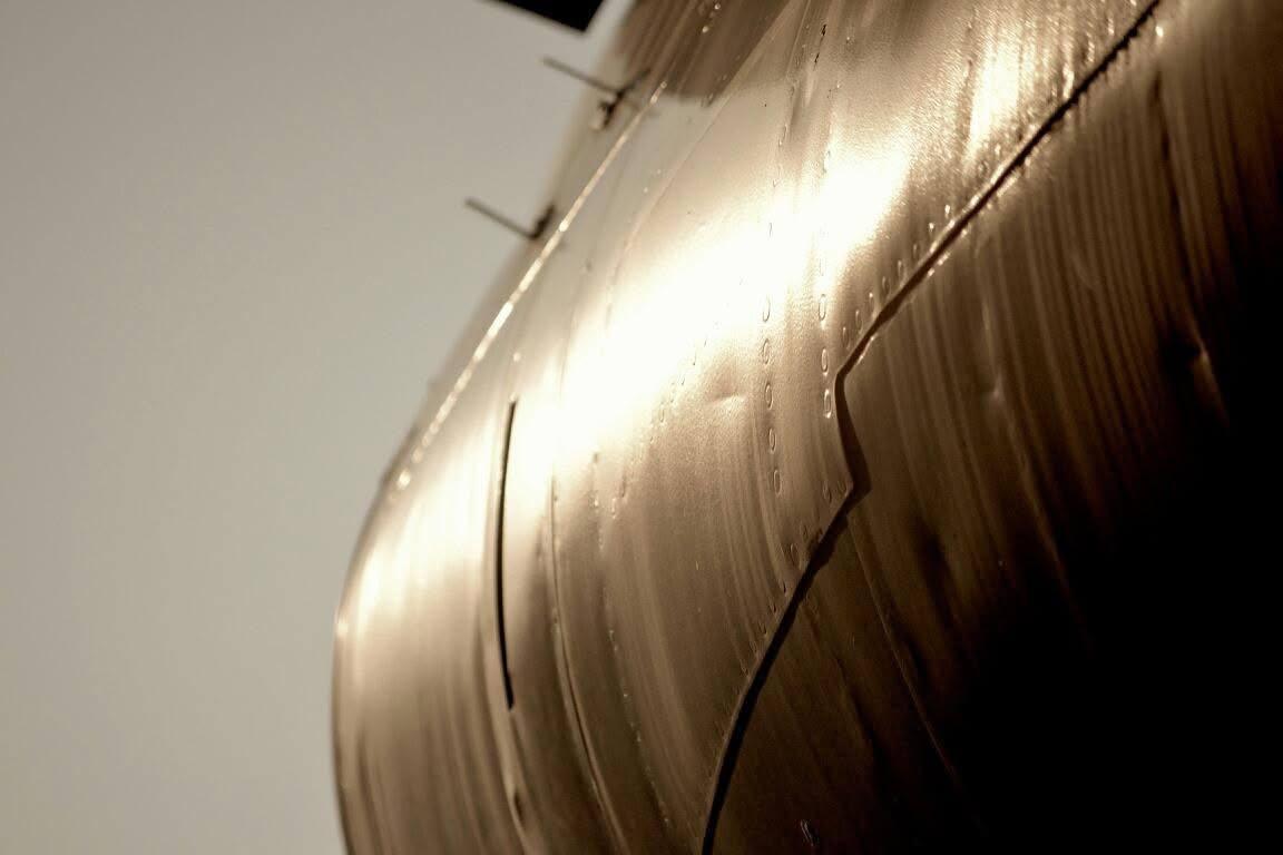 Warm light reflecting across the curved metal skin of an airplane