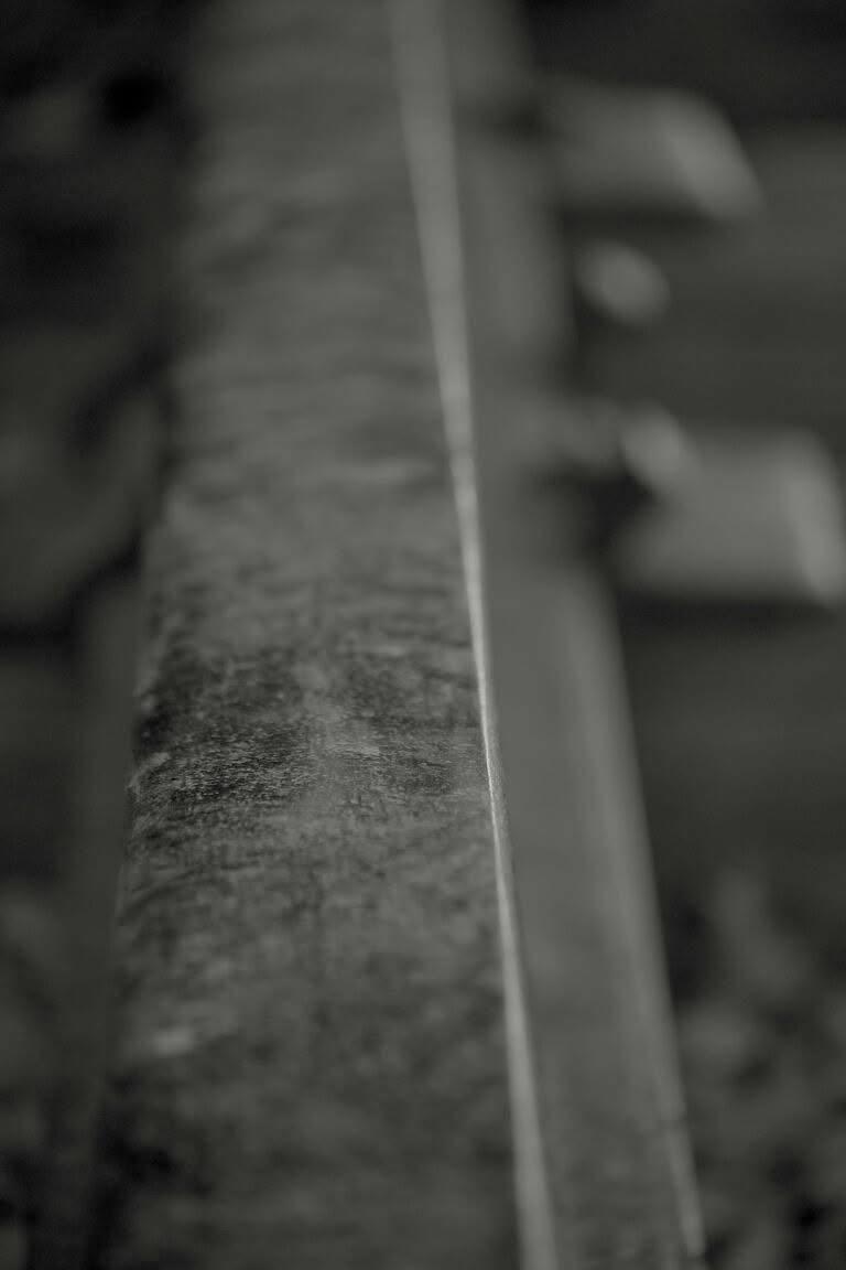A shallow-focus black-and-white study along the edge of a rail track