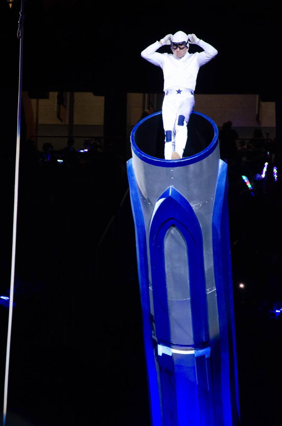 A human cannonball performer suspended in midair above the circus ring