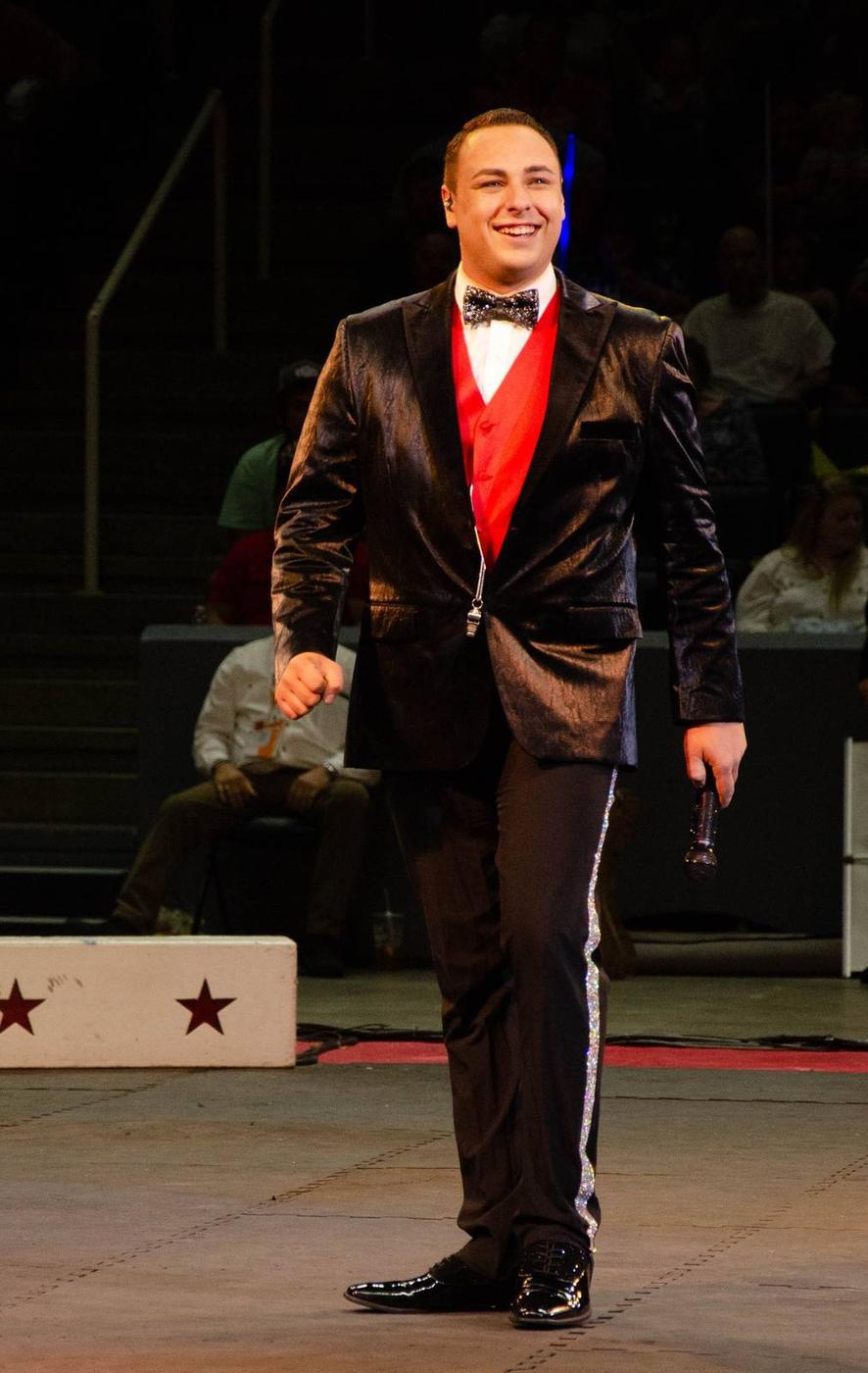 An aerial circus performer suspended high above the ring